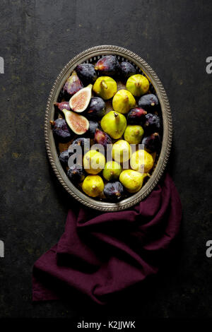 Figues fraîches dans un bac en métal sur fond noir Banque D'Images