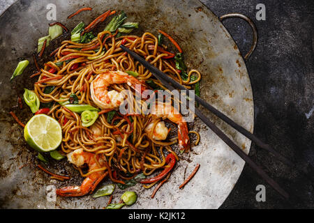 Les nouilles Udon sautés avec légumes et crevettes Tiger wok casserole de cuisson en close-up Banque D'Images
