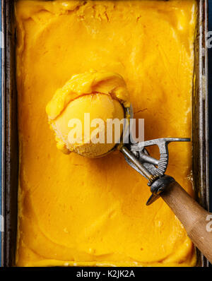 Mango Sorbet ice cream ball dans scoop close-up Banque D'Images