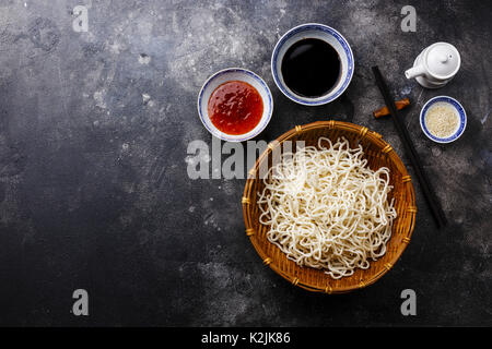 Les nouilles Udon dans panier de bambou avec des sauces et sésame sur fond sombre copy space Banque D'Images