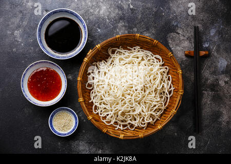 Les nouilles Udon dans panier de bambou avec des sauces et sésame sur fond sombre Banque D'Images