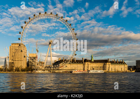 London's Southbank glourious baigné de soleil du printemps alors que le soleil se couche sur la Tamise. Le London Eye, l'aquarium et bâtiment shell peut être vu. Banque D'Images