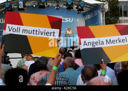 Erlangen, Allemagne. Août 30, 2017. La chancelière allemande, Angela Merkel, s'exprimant lors d'un événement de campagne de la CSU à Erlangen, Allemagne, 30 août 2017. Au premier plan, de supports sensibilisation des affiches avec les textes "muttiviert pleinement' et 'Angela Merkel'. Photo : Daniel Karmann/dpa/Alamy Live News Banque D'Images