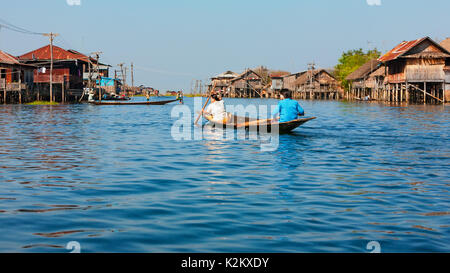 Lac Inle, Myanmar - janvier 04, 2007 : Les Birmans voyageant par bateau long aviron aux pêcheurs traditionnels village avec des maisons sur pilotis sur l'eau Banque D'Images