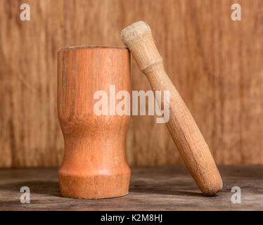 Mortier et pilon en bois sur un fond de bois et de surface, d'une cuisine et d'ustensile de cuisine, appareils pour le mélange et l'griding Banque D'Images