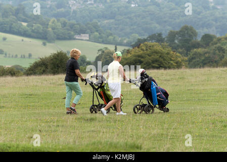 Dame golfeurs dans le sud de la région des Cotswolds England UK. Marcher avec leurs caddies électriques le acrodd à Minchinhampton Common Gloucestershire.A Banque D'Images