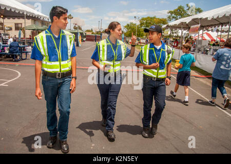 Les hommes et les femmes hispaniques des ados Explorer Scouts servir comme auxiliaire de police lors d'une foire de rue à Costa Mesa, CA. Banque D'Images