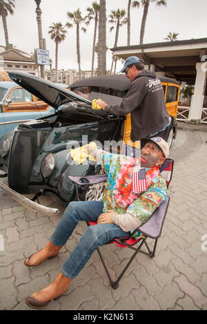 Une voiture classique collector polit ses 1947 Ford 'woodie' station wagon sur l'affichage à une exposition de voiture au centre-ville de Huntington Beach, CA. Remarque mascot mannequin surnommé 'Homer Huggins.' Banque D'Images