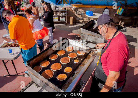 Un chef cuisine des crêpes sur un gril extérieur lors d'un festival à Huntington Beach, CA. Banque D'Images