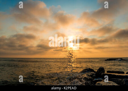 Moody matin sur la plage avec de l'eau splash sur l'avant-plan et ciel nuageux sur l'arrière-plan Banque D'Images