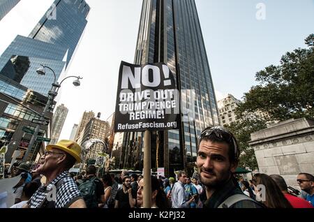 New York City, New York, USA. Août 30, 2017. Un homme est titulaire d'un anti-Trump/Pence inscription en face de l'hôtel Trump International. En raison de l'examen de la Loi sur la DACA (ACTION DIFFÉRÉE POUR DES ARRIVÉES DE LA PETITE ENFANCE) par l'Administration d'atout, ainsi que l'attente de la suppression du programme, 1 500 New-Yorkais se sont réunis à l'hôtel Trump International à manifester leur soutien à la loi. La Loi sur la protection contre DACA donne l'expulsion des sans-papiers pour les jeunes de moins de 31 ans, tant qu'ils remplissent certaines exigences. En outre, l'ac Banque D'Images