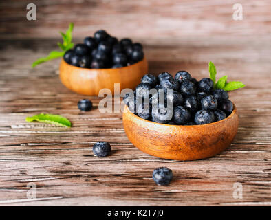 Les airelles fraiches ou des bleuets dans de petits bols en bois sur une table rustique, selective focus Banque D'Images