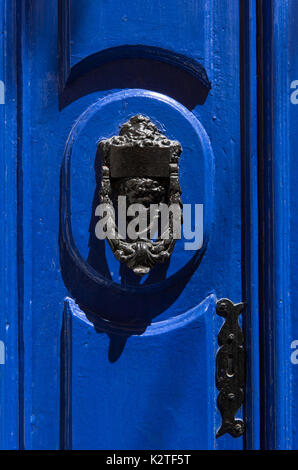 Poignée de porte en bronze décoratifs sous la forme d'une belle tête de la femme sur une porte peinte en bleu. Malte Banque D'Images