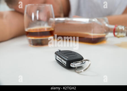 Close-up de l'homme ivre avec le verre d'alcool et de clé de voiture Banque D'Images