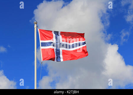 Pavillon de la Norvège contre le ciel bleu et nuages blancs. Le pavillon de la Norvège est rouge avec une croix scandinave bleu indigo, lisérée de blanc. Banque D'Images