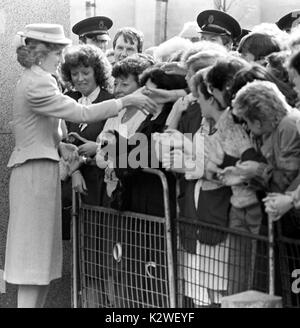 Diana, princesse de Galles, accueille une main tendue qu'elle rencontre la foule qui se sont réunis en Ulster pour sa visite surprise. Banque D'Images