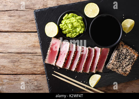 Plateau ardoise avec des tranches de steak de thon poêlé au sésame libre. Vue de dessus d'au-dessus de l'horizontale Banque D'Images