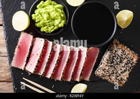 Le thon frais viande dans le sésame et la sauce soja, wasabi, de chaux libre sur la table. Vue de dessus d'au-dessus de l'horizontale Banque D'Images