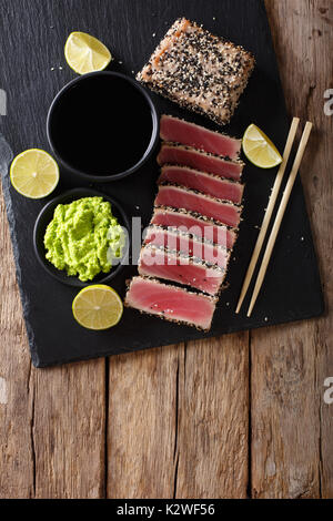 Plateau ardoise avec des tranches de steak de thon poêlé au sésame libre. Haut de la vue de dessus à la verticale Banque D'Images