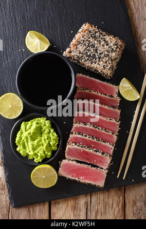 Le thon frais viande dans le sésame et la sauce soja, wasabi, de chaux libre sur la table. Haut de la vue de dessus à la verticale Banque D'Images