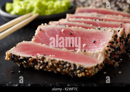 Belle alimentation : steak de thon en tranches avec macro sésame sur la table horizontale. Banque D'Images