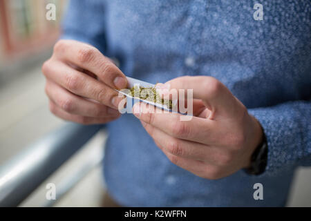 Close up of a man's hands rouler un joint de marijuana Banque D'Images