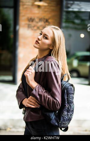 Portrait of young happy smiling dame marche sur la rue, holding bag Banque D'Images