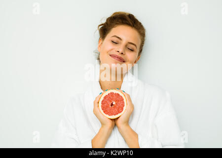 Happy woman in bath towel montrant son fruit préféré, le pamplemousse Banque D'Images