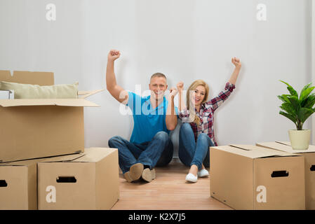 Portrait de jeune couple excité avec boîtes de carton dans la nouvelle maison Banque D'Images