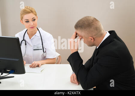 Patient de sexe masculin avec de jeunes femme médecin à la clinique Banque D'Images