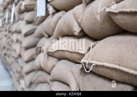 Vieux chanvre sacs contenant coffee bean en entrepôt. sacs empilés en entrepôt. Banque D'Images