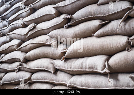 Vieux chanvre sacs contenant coffee bean en entrepôt. sacs empilés en entrepôt. Banque D'Images