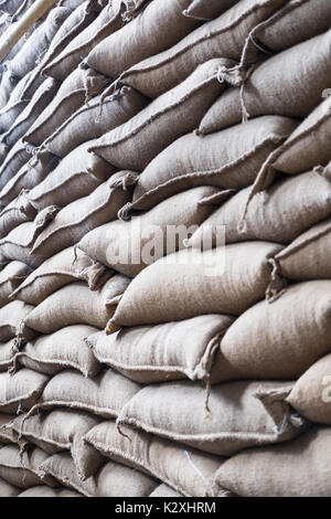 Vieux chanvre sacs contenant coffee bean en entrepôt. sacs empilés en entrepôt. Banque D'Images