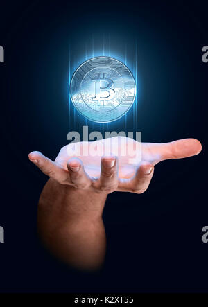 Un homme part évoquant un bitcoin bleu flottant dans l'hologramme cryptocurrency pièces physiques sur un arrière-plan sombre studio Banque D'Images