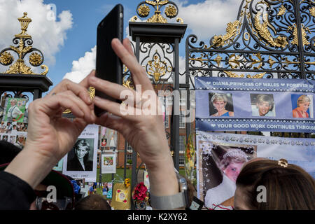 Comme la foule des sympathisants royalistes recueillir, un mémorial de spontanée des fleurs, les photos et les souvenirs se développant à l'extérieur de Kensington Palace, la résidence royale de la princesse Diana, morte dans un accident de voiture à Paris il y a 20 ans exactement, le 31 août 2017, à Londres, en Angleterre. En 1997 une mer de tributs floraux aussi rempli cette zone du parc royal ainsi que dans le centre commercial où ses funérailles. Alors, comme aujourd'hui - un royalistes ont pleuré la princesse du peuple, un intitulé inventé par le Premier Ministre Tony Blair. Banque D'Images