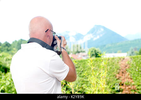 Un homme mûr photographies les montagnes Banque D'Images