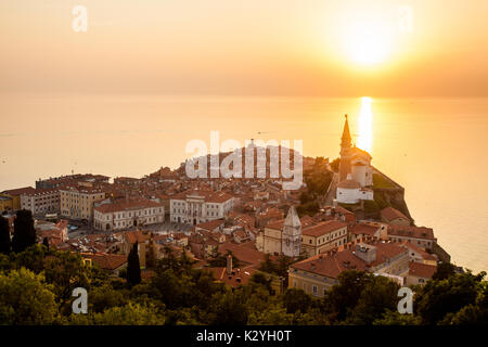 Coucher du soleil au-dessus des murs de la ville de Piran. Ville vénitienne de Piran, construit sur la petite péninsule a été fortifiée par des murs sur le côté continental. Banque D'Images