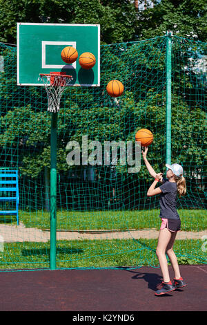 Joueur de basket-ball fille lance la balle dans le panier Banque D'Images