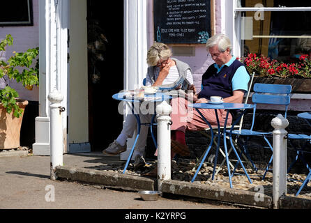 Senior couple sitting outside cafe à Burnham market, North Norfolk, Angleterre Banque D'Images