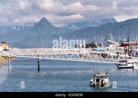 Un petit bateau de pêche chefs sur la mer depuis la ville d'Homer et Port de plaisance port donnant sur Kamishak Bay et la montagnes Kenai dans Homer, Alaska. Banque D'Images