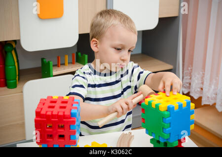 Petit Garçon jouant avec des blocs sur une table. enfant jeune garçon enfant garderie jeux block construire concept Banque D'Images