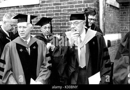 Des professeurs de l'Université Johns Hopkins en robe universitaire se tiennent à l'extérieur d'un bâtiment académique de briques suivant la classe de l'Université de 1956, cérémonie à Baltimore, Maryland, le 12 juin 1956. Banque D'Images