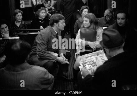 1970s UK London tube, train souterrain couple de navetteurs sur les trains bondés pendant l'heure de pointe. Homme lisant le journal Evening News, tout le monde sur le chemin de la maison après le travail. Londres transport 1970 Angleterre HOMER SYKES Banque D'Images