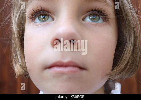 Portrait d'une fille brune aux yeux verts à la recherche jusqu'à l'étonnant Banque D'Images