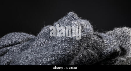 Fait main laine cachemire gris froissé la texture de tissu sur un fond noir. Banque D'Images
