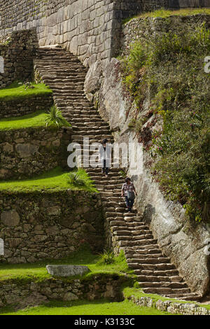 Les touristes sur l'escalier de pierre, les ruines Inca de Machu Picchu (Site du patrimoine mondial), la Vallée Sacrée, le Pérou, Amérique du Sud Banque D'Images