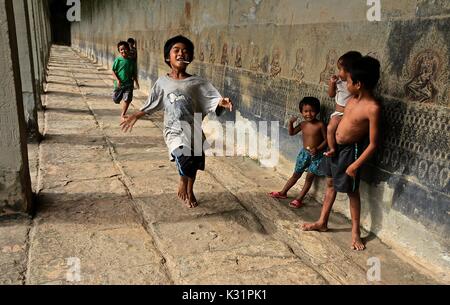 Les enfants cambodgiens tenir une course impromptue dans un temple à Angkor Wat, au Cambodge Banque D'Images