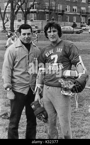 Portrait photographique de gris de l'homme joueur de Johns Hopkins University, portant un numéro 7 jersey et tenant sa couronne, debout sur le terrain à côté de l'entraîneur-chef Henry Ciccarone, Baltimore, Maryland, 1978. Banque D'Images