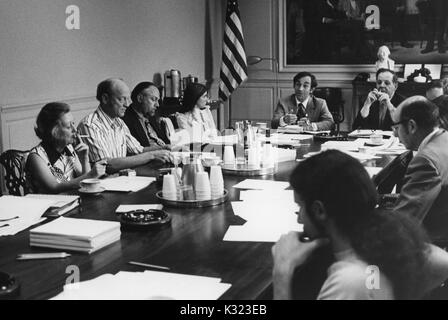 Les membres de faculté et de l'administration à l'Université Johns Hopkins et Goucher College se rassemblent pour une réunion à une longue table de conférence avec des papiers, des tasses à café, et des cendriers éparpillés sur, Baltimore, Maryland, 1975. Banque D'Images