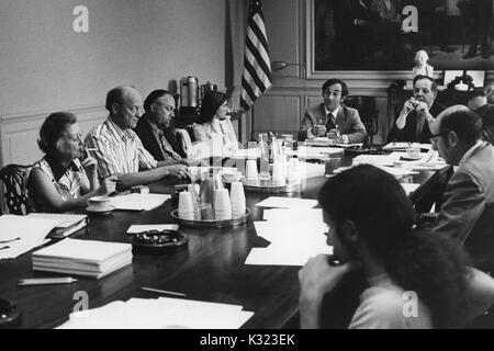 Les membres de faculté et de l'administration à l'Université Johns Hopkins et Goucher College se rassemblent pour une réunion à une longue table de conférence avec des papiers, des tasses à café, et des cendriers éparpillés sur, Baltimore, Maryland, 1975. Banque D'Images